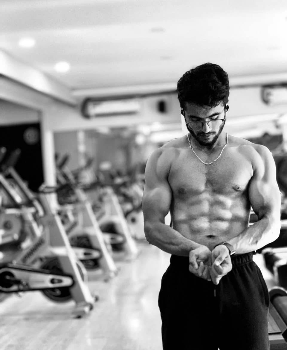 Original black-and-white physique portrait of Abdeali in the gym